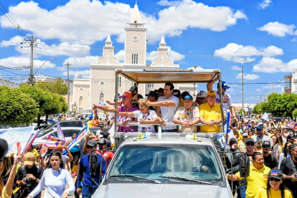 Lucas Ribeiro, Leninha Romão, Zé Aldemir, João Azevêdo e Nabor Wanderley acenam em carro aberto em frente à igreja matriz.